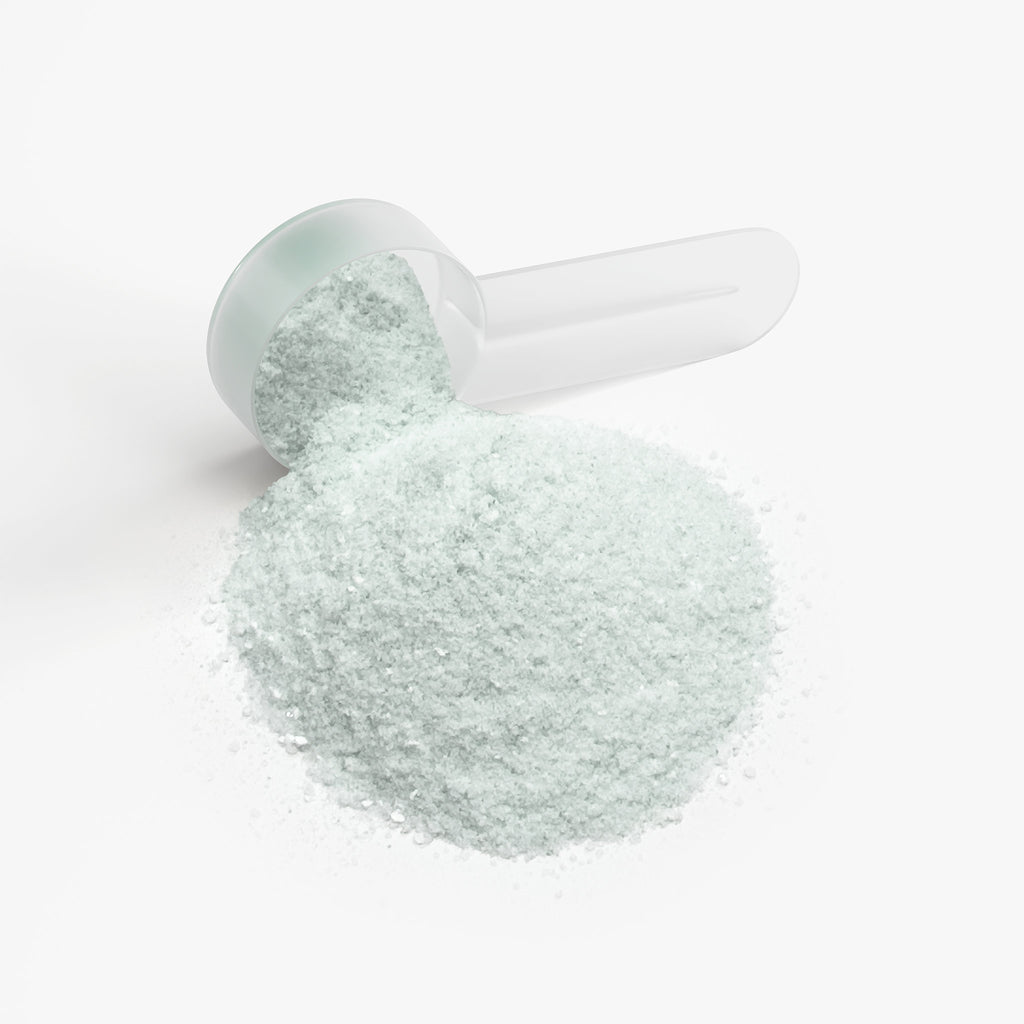 White scoop filled with focus powder on a white background