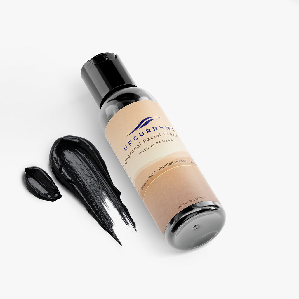 Upcurrent facial cleanser bottle with black cleansing stick on a white background