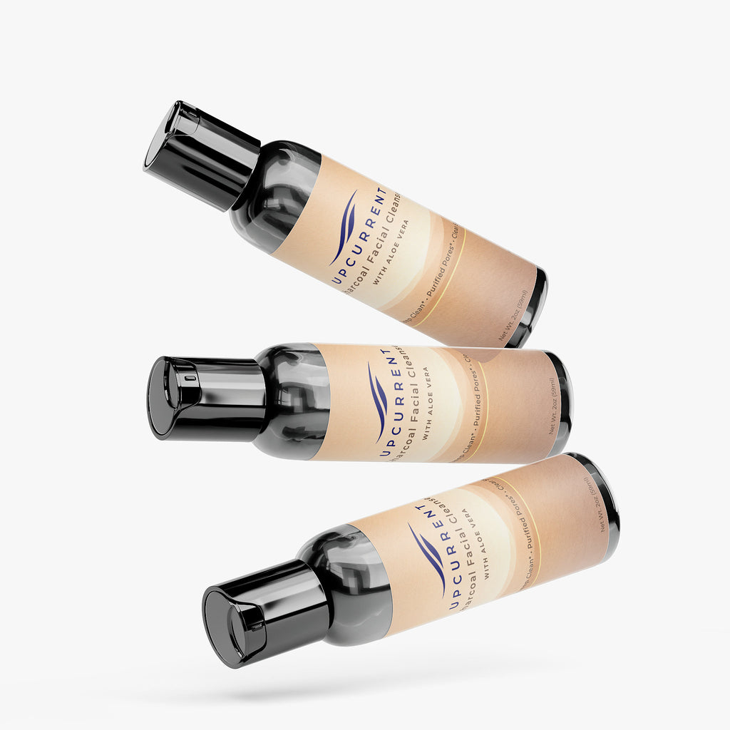 Three bottles of Upcurrent Charcoal Facial Cleanser with visible labels on a white background