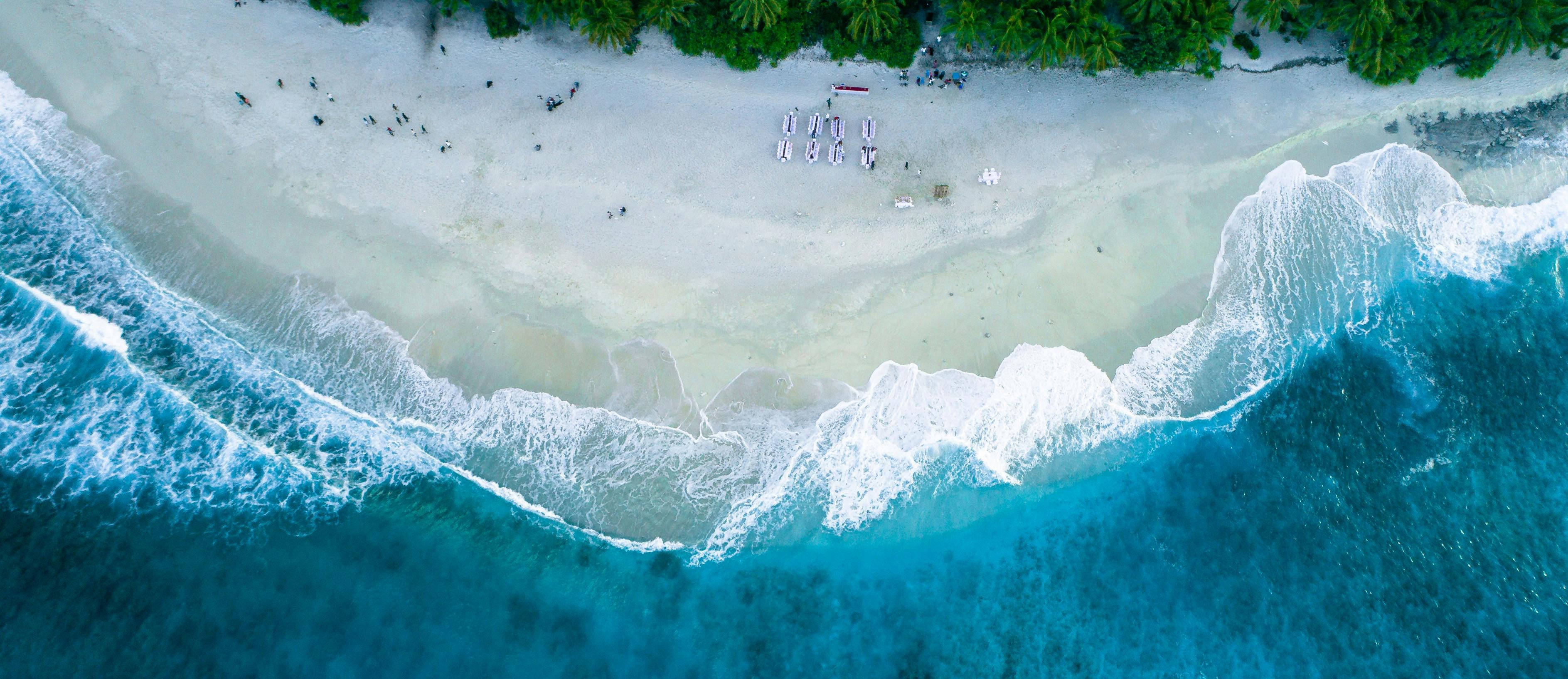 Aerial view of a beach with turquoise water and white sand.